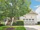 Home exterior with a lush green lawn and large tree, showcasing the two-car garage and inviting entrance at 214 Ashdown Forest Ln, Cary, NC 27519