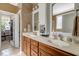 Bathroom with a double sink vanity, framed mirrors, and an open door to a walk-in closet at 218 Kinvara Ct, Wake Forest, NC 27587