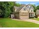 Beautiful home exterior with a stone facade, attached garage, and lush green lawn at 218 Kinvara Ct, Wake Forest, NC 27587