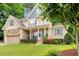 Inviting home exterior featuring a covered porch, stone accents, and a well-maintained yard at 218 Kinvara Ct, Wake Forest, NC 27587