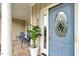 Charming front porch with seating, potted plant, and a decorative blue front door at 218 Kinvara Ct, Wake Forest, NC 27587