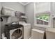 Functional laundry room equipped with a washer, dryer, shelving, and a window for natural light at 218 Kinvara Ct, Wake Forest, NC 27587