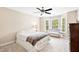 Bright bedroom with a ceiling fan, a tufted loveseat, and a bay window providing ample natural light at 221 Roebling Ln, Cary, NC 27513