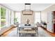 Elegant dining room with modern chandelier, large windows, and stylish furnishings at 221 Roebling Ln, Cary, NC 27513