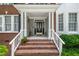 Inviting front porch with brick steps, white columns, and decorative accents at 221 Roebling Ln, Cary, NC 27513