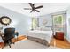 Bright main bedroom with hardwood floors, a ceiling fan, and an adjacent office space at 221 Roebling Ln, Cary, NC 27513