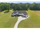 Aerial view of a stunning farmhouse-style home with expansive green lawns at 2229 Neills Creek Rd, Lillington, NC 27546