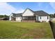 Spacious backyard with a view of the house, including two screened-in porches and a stone patio at 2229 Neills Creek Rd, Lillington, NC 27546