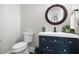 This half bath features a stylish vanity with a modern vessel sink and decorative round mirror above at 2229 Neills Creek Rd, Lillington, NC 27546