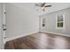 This bedroom has hardwood floors, two large windows, a ceiling fan, and neutral paint at 2229 Neills Creek Rd, Lillington, NC 27546