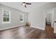 Bedroom with hardwood flooring, ceiling fan, and two windows; bright and neutral, ready to be personalized at 2229 Neills Creek Rd, Lillington, NC 27546