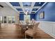 Elegant dining room with coffered ceiling, blue walls, and views of the outdoor screened porch at 2229 Neills Creek Rd, Lillington, NC 27546