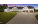 Charming white farmhouse-style home featuring a well-manicured lawn, covered porch, and a three-car garage at 2229 Neills Creek Rd, Lillington, NC 27546