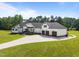 Beautiful white farmhouse-style home featuring a long driveway and well-manicured landscaping at 2229 Neills Creek Rd, Lillington, NC 27546