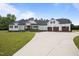 Stunning, modern farmhouse with a three-car garage, well-manicured lawn, and a circular driveway at 2229 Neills Creek Rd, Lillington, NC 27546
