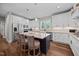 Bright kitchen with white cabinets, stainless appliances, granite counters, and dark island with barstool seating at 2229 Neills Creek Rd, Lillington, NC 27546