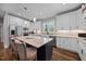 Bright kitchen with white cabinets, stainless appliances, granite counters, and dark island with barstool seating at 2229 Neills Creek Rd, Lillington, NC 27546