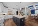 Open concept kitchen featuring a dark island with barstool seating flowing into a living and dining area at 2229 Neills Creek Rd, Lillington, NC 27546