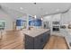 Open concept kitchen and dining area with a dark kitchen island, stainless appliances, and white cabinetry at 2229 Neills Creek Rd, Lillington, NC 27546