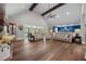 Open-concept living room featuring vaulted ceiling, wood beams, and access to an outdoor screened porch at 2229 Neills Creek Rd, Lillington, NC 27546
