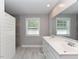 Contemporary bathroom with double sink, modern fixtures, a walk-in shower with white shiplap walls, and natural light at , Holly Springs, NC 27540