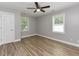 Bright bedroom featuring wood-look floors, a ceiling fan, and windows with natural light at , Holly Springs, NC 27540