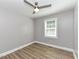 Cozy bedroom with hardwood floors, ceiling fan, natural light from a window, and neutral color palette at , Holly Springs, NC 27540
