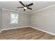 Bright bedroom with a ceiling fan, wood-look floors and neutral gray walls at , Holly Springs, NC 27540