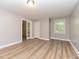 Light-filled bedroom featuring hardwood floors, neutral walls, a window and a door with glass inserts at , Holly Springs, NC 27540
