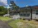 A charming gray two-story townhouse features a front porch with white railings and well-manicured landscaping at , Holly Springs, NC 27540