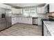 Modern kitchen with white cabinets, stainless steel appliances, and hardwood-style floors at , Holly Springs, NC 27540