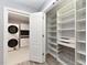 Bright laundry room with organized shelving and a modern, stacked washer and dryer set for efficient space saving at , Holly Springs, NC 27540