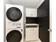 Close-up of stacked washer and dryer with sleek black accents and modern fixtures, complemented by custom cabinet space at , Holly Springs, NC 27540