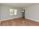Bright living room with wood-look floors and ample natural light through large windows at , Holly Springs, NC 27540