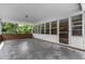 Enclosed porch with brick accents, white trim, and a view of the surrounding greenery at 2291 Gentry Ridge Rd, Roxboro, NC 27574