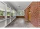 Sunroom featuring a brick accent wall, whitewashed ceiling, and windows offering an abundance of natural light at 2291 Gentry Ridge Rd, Roxboro, NC 27574