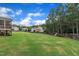 Expansive backyard with lush green lawn, screened porch, and mature trees creating a serene oasis at 2300 Ginger Gold Court, Apex, NC 27539