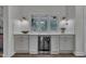 Charming wet bar with white cabinets, beverage fridge, and views of lush greenery at 2300 Ginger Gold Court, Apex, NC 27539