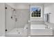 Bright bathroom features a glass walk-in shower and soaking tub with wood look floors at 2300 Ginger Gold Court, Apex, NC 27539
