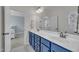 Bathroom featuring double vanity, blue cabinets, and view into bedroom at 2300 Ginger Gold Court, Apex, NC 27539