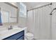 Bright bathroom featuring vanity with blue cabinets and shower with curtain at 2300 Ginger Gold Court, Apex, NC 27539