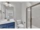 Nicely decorated bathroom featuring modern vanity, large mirror, toilet, and glass-enclosed shower at 2300 Ginger Gold Court, Apex, NC 27539