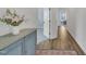 Hallway leading to various rooms with hard wood flooring and rustic cabinet at 2300 Ginger Gold Court, Apex, NC 27539