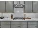 Close-up of kitchen featuring marble counters, subway tile backsplash, and stainless steel gas cooktop at 2300 Ginger Gold Court, Apex, NC 27539