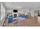 Bright living room with fireplace, comfortable blue sofas, hardwood flooring, and stairs at 2300 Ginger Gold Court, Apex, NC 27539
