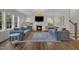 Bright living room featuring a fireplace, comfortable blue sofas, hardwood floors, and ample natural light at 2300 Ginger Gold Court, Apex, NC 27539