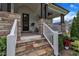 Close-up of a welcoming front porch with stone steps, white railings, and dark wood pillars at 2300 Ginger Gold Court, Apex, NC 27539