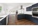 Open concept kitchen with stainless appliances, white countertops and island, with dark blue cabinets at 2318 E Main St, Durham, NC 27703