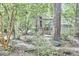 Wooded backyard with a wooden swing, lush greenery, and a winding stone path, creating a serene retreat at 2334 Dawn Trl, Durham, NC 27712