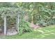 Charming backyard with a vine-covered pergola, lush greenery, and a well-maintained lawn at 2334 Dawn Trl, Durham, NC 27712